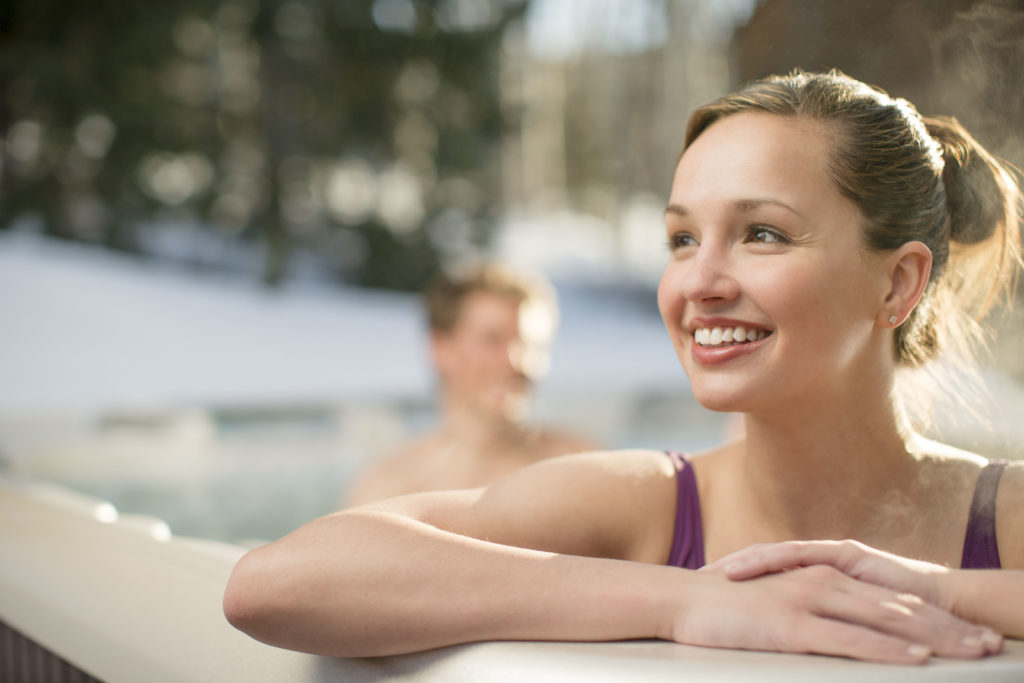 Clean water from good hot tub maintenance makes this brunette very happy as she sits in a hot tub