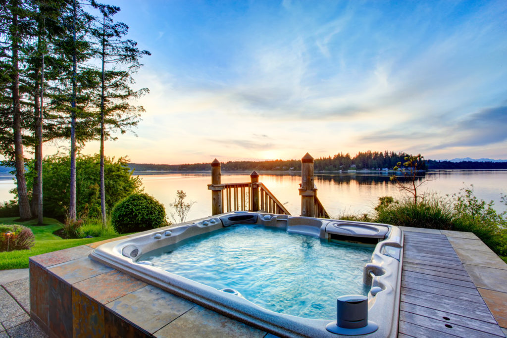 Awesome water view with hot tub in summer evening. House exterior.