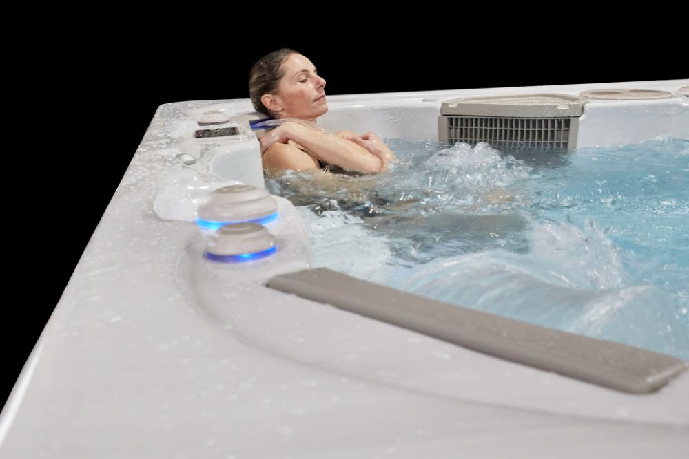 Woman relaxing in Hydropool swim spa - Great Bay Spa & Sauna explains the benefits of exercising in a swim spa.