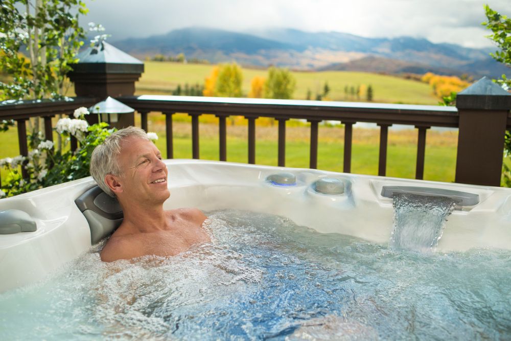 man relaxing in Sundance® Spa - Great Bay Spa & Sauna explains how a hot tub can help with arthritis.