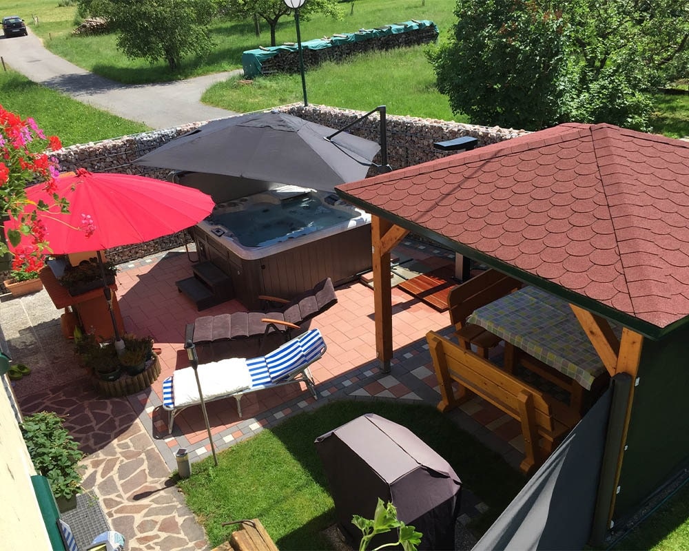 backyard with hot tube, big umbrellas  and pool lounge chairs