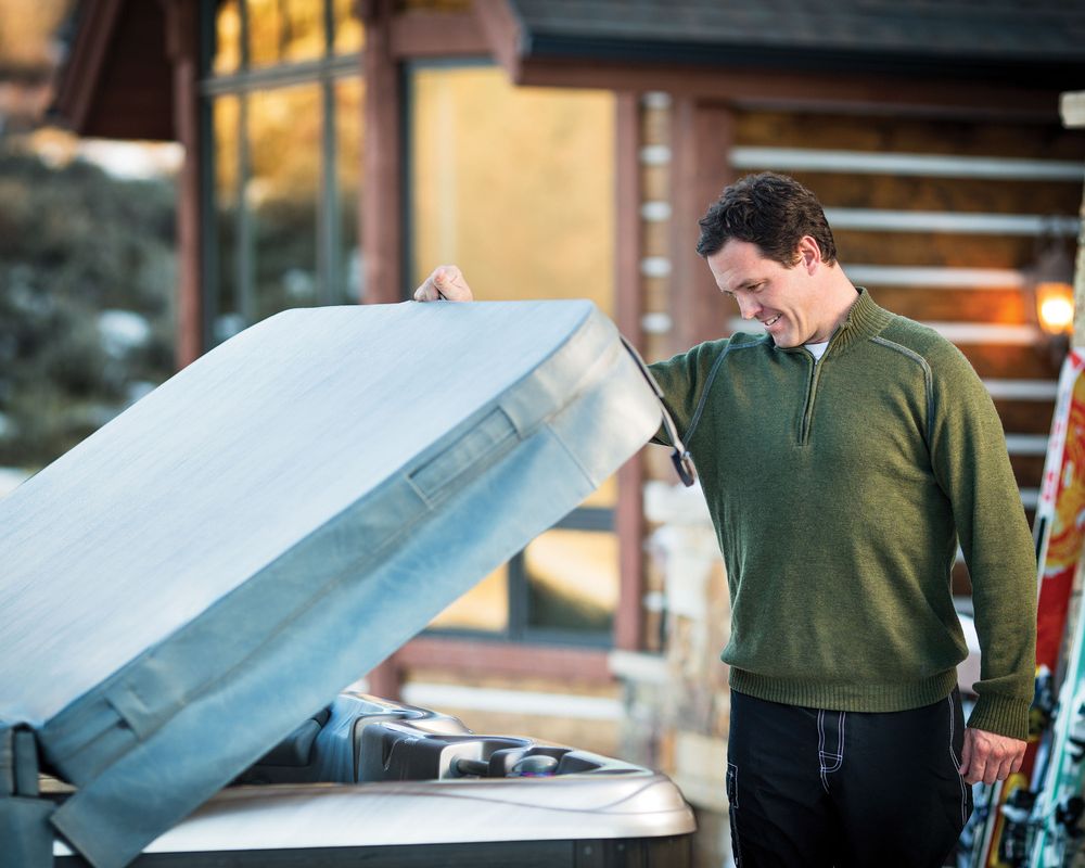 man opening hot tub cover