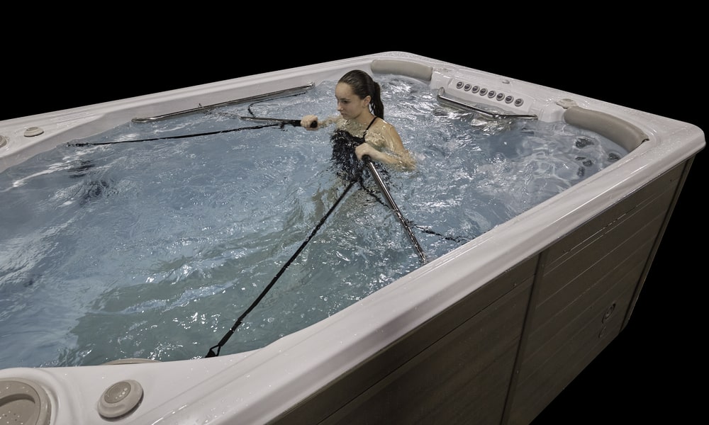 woman is exercising in swim spa using row fit set