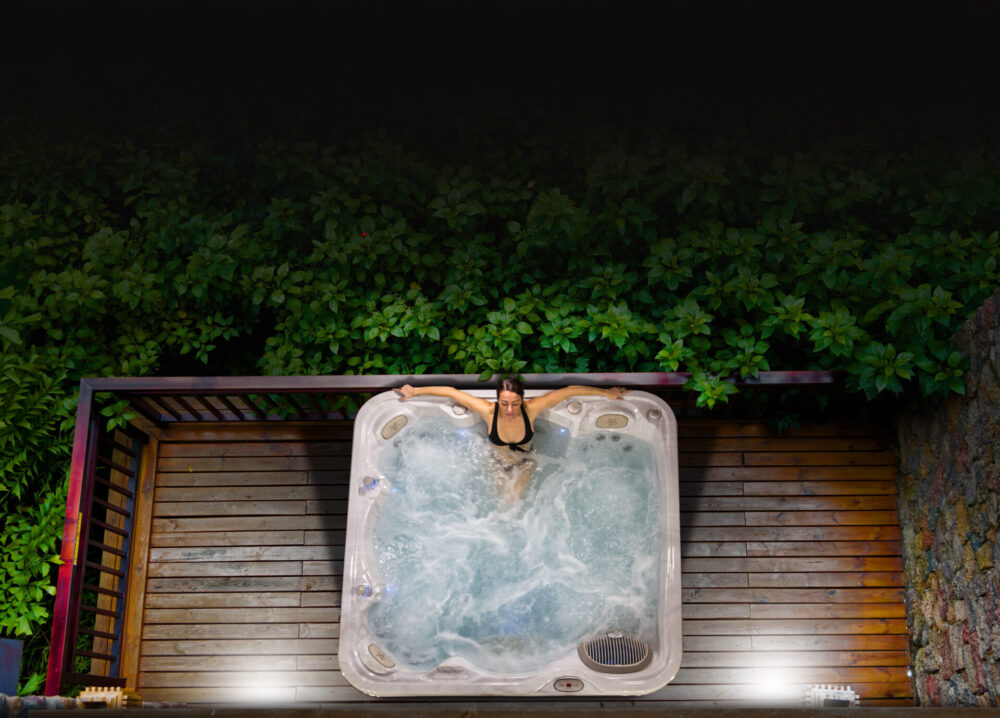 A zoomed-out shot of a hot tub at night.